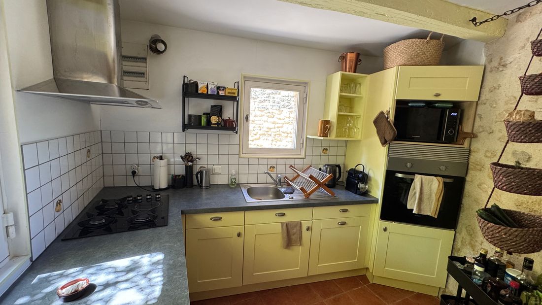 La cuisine aux tons jaune doux, baignée de lumière