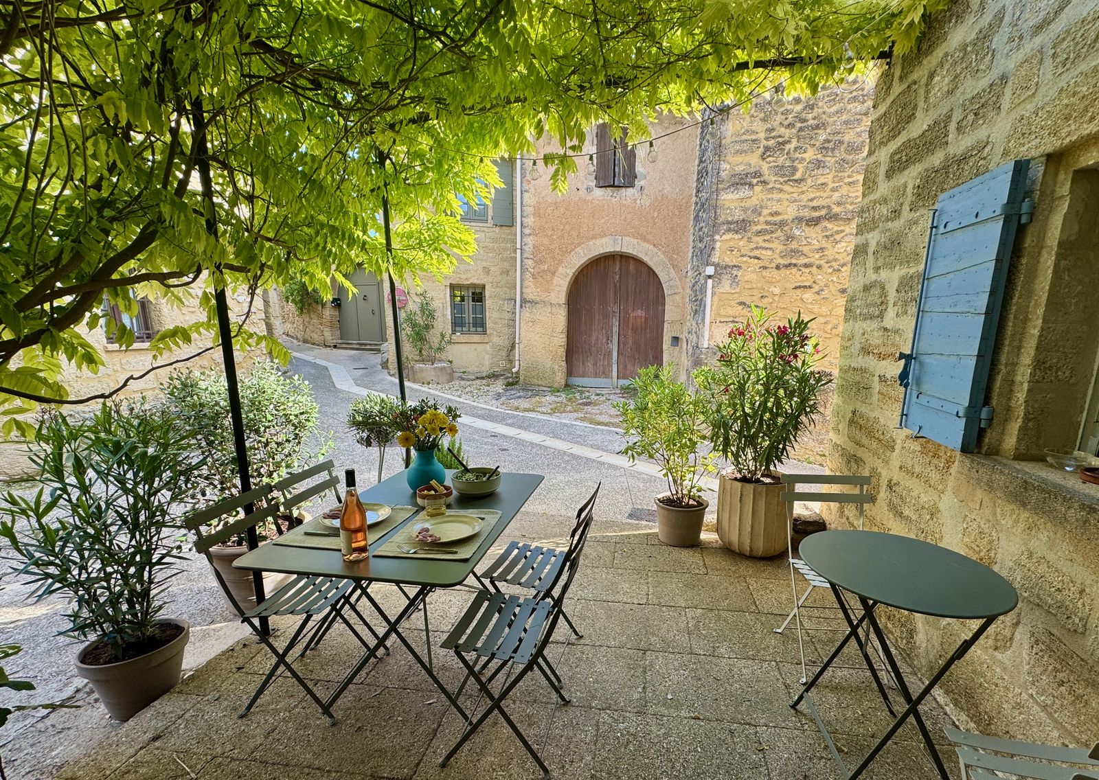 La table dressée sous la glycine, vue depuis la terrasse
