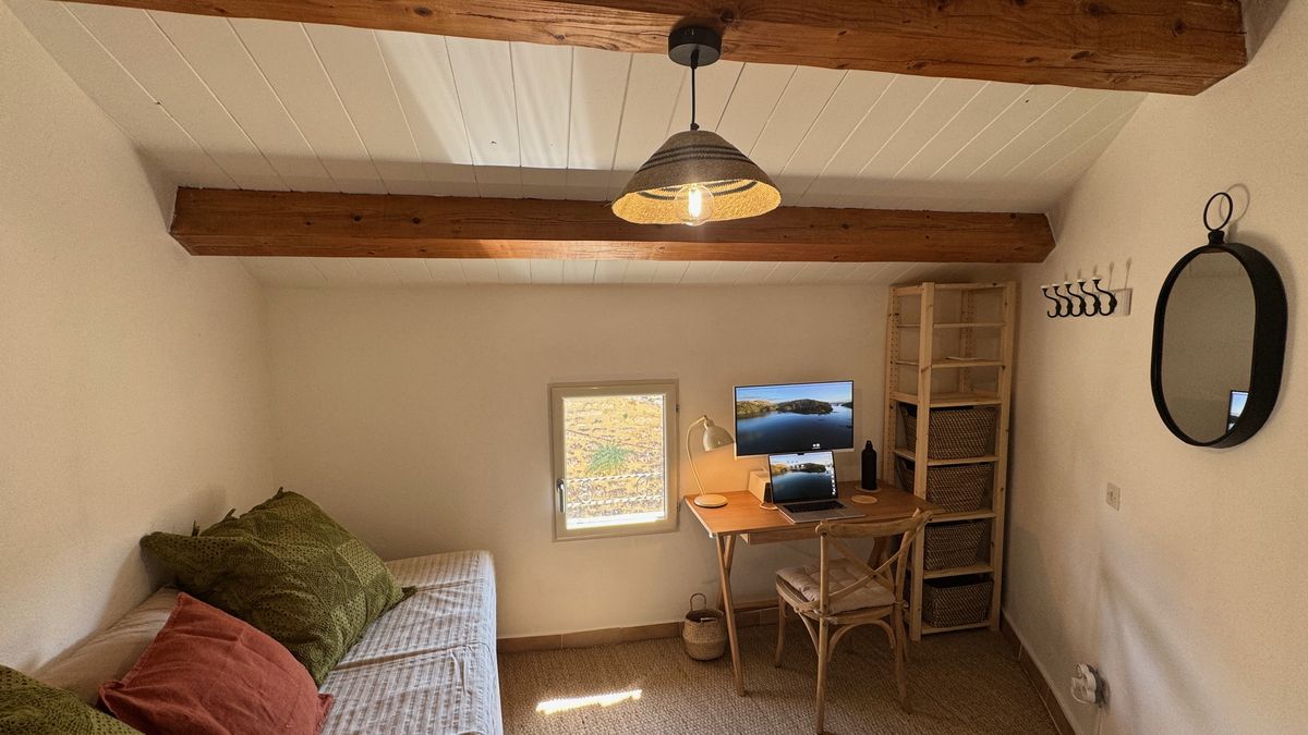 La chambre de la tourelle sous les poutres, lit et poste de travail